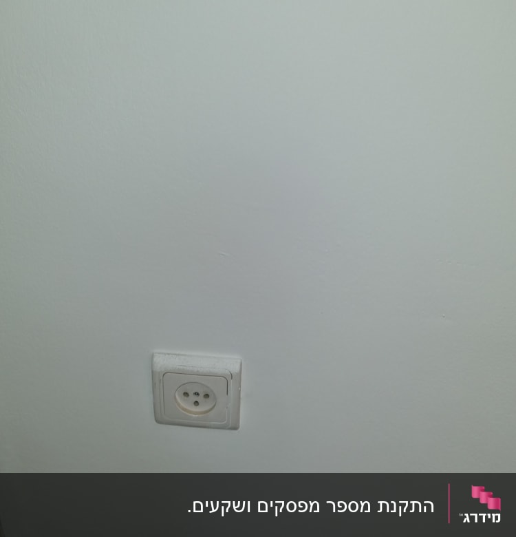שקע חשמל בקיר לבן